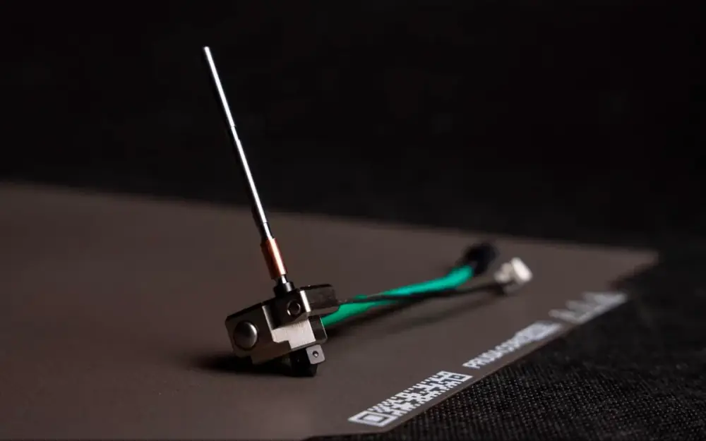 Високотемпературний хотенд Prusa HT Hotend із мідним нагрівачем і зеленим кабелем на пластині столу